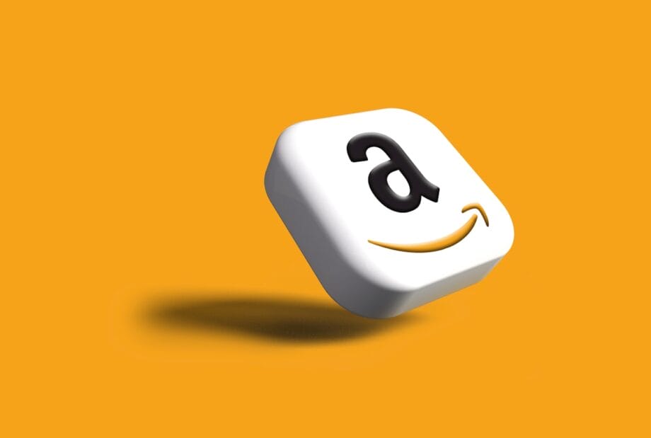 A 3D square icon with the Amazon logo on a solid orange background, casting a shadow below.