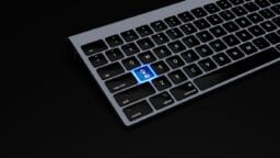 Partial view of a keyboard with a highlighted blue key labeled AI featuring a hand icon, set against a black background.