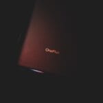 Close-up of a OnePlus smartphone partially illuminated against a dark background.