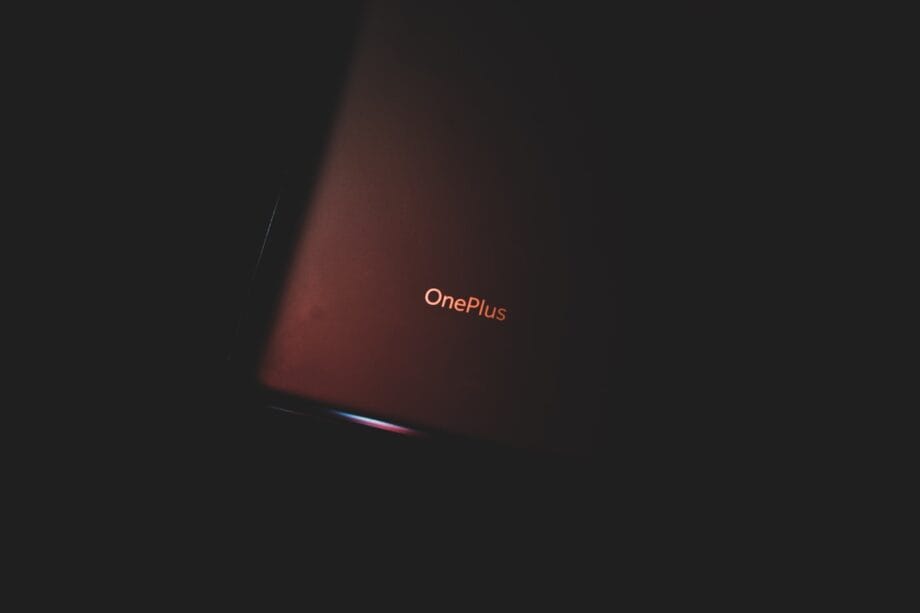Close-up of a OnePlus smartphone partially illuminated against a dark background.