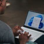 man in gray long sleeve shirt using Windows 11 computer