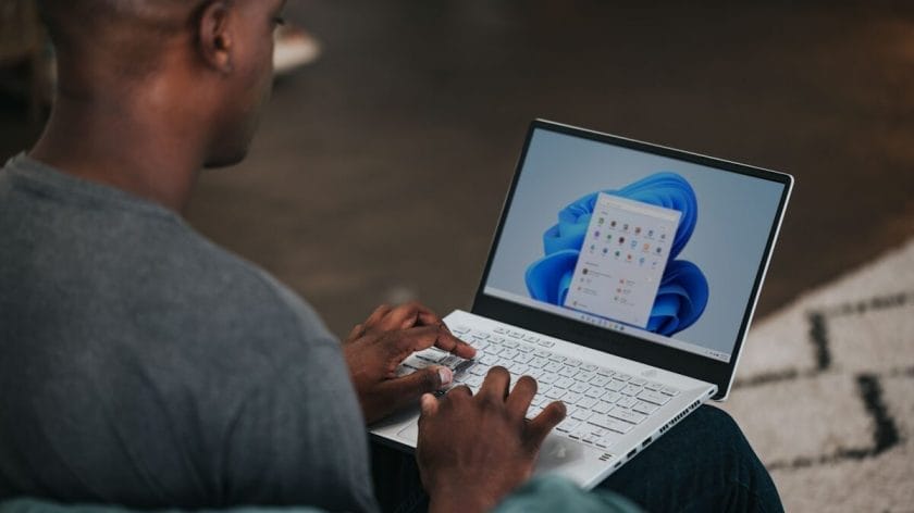 man in gray long sleeve shirt using Windows 11 computer