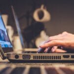 person using silver laptop computer on desk