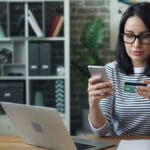 a woman sitting at a table looking at her cell phone