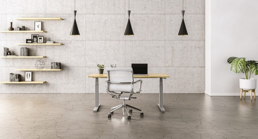 Minimalist office with a desk, white chair, laptop, three black pendant lights, wall shelves, and a potted plant on a concrete floor.