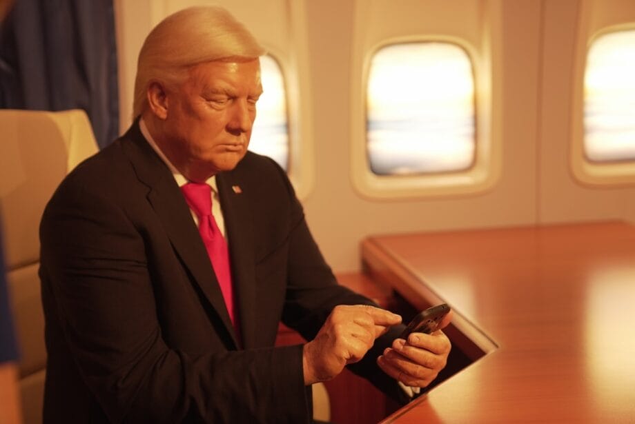 a man in a suit and tie looking at a cell phone