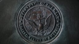 silver round coin on gray textile