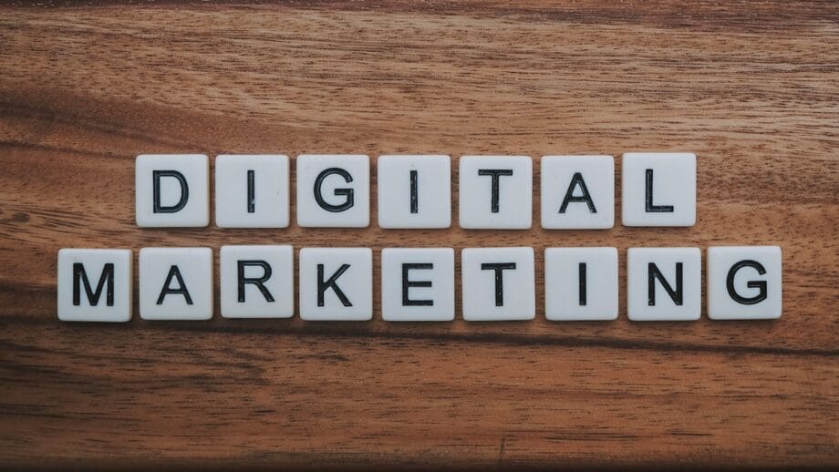 Scrabble tiles on a wooden surface spell out Digital Marketing in two rows.