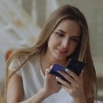 Young woman holding credit card and smartphone