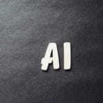 Wooden letters spelling AI placed on a dark, textured background.