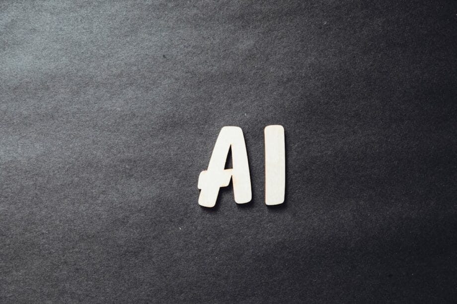 Wooden letters spelling AI placed on a dark, textured background.