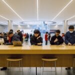 People using devices at an apple store.