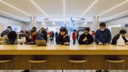 People using devices at an apple store.