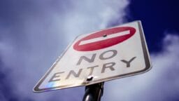 a no entry sign is shown against a blue sky