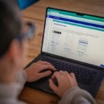 Person using a laptop, viewing a website page titled Executive Summary with document templates displayed on the screen.