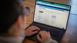 Person using a laptop, viewing a website page titled Executive Summary with document templates displayed on the screen.