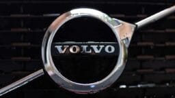 Close-up of a Volvo car emblem on the front grille, showing the brand name in chrome letters against a black background.