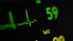 Close-up of a medical monitor displaying a heart rate of 59 bpm and a SpO2 reading of 99.