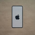 an iphone is sitting on a brown surface