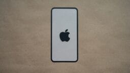 an iphone is sitting on a brown surface