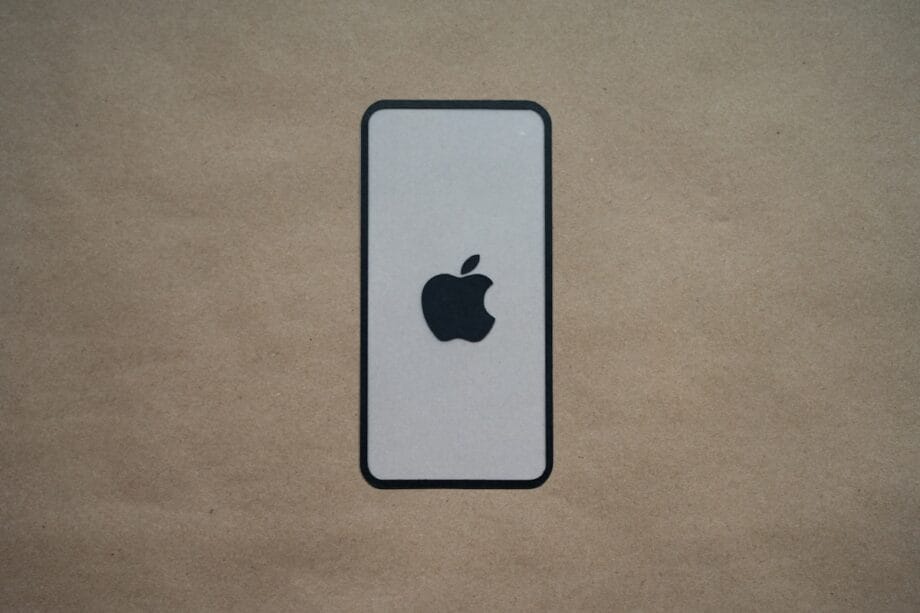 an iphone is sitting on a brown surface