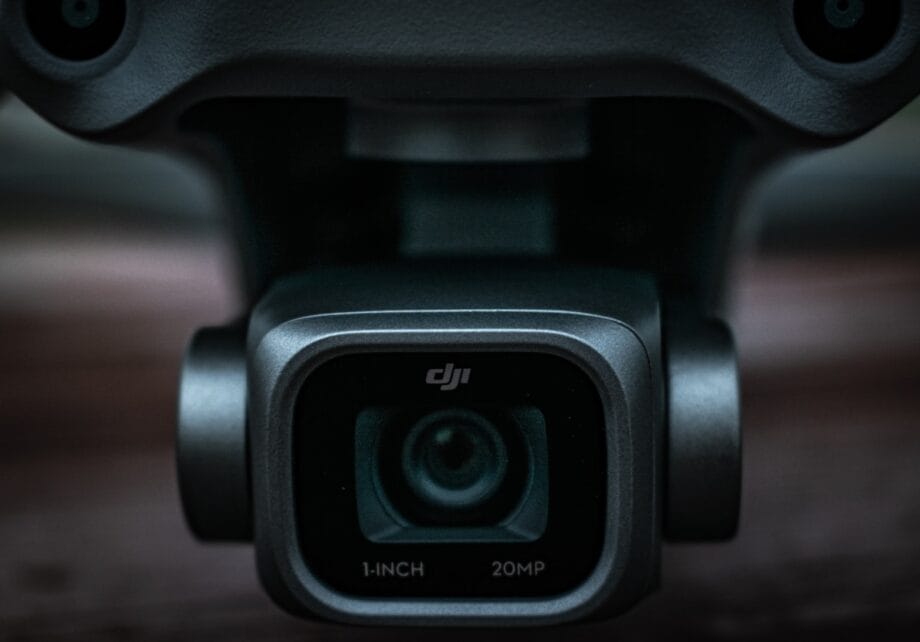 Close-up of a DJI camera lens on a drone, showing 1-INCH 20MP text below the lens.