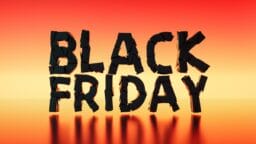 Black Friday text in bold black 3D letters on a red and orange gradient background with reflections below.