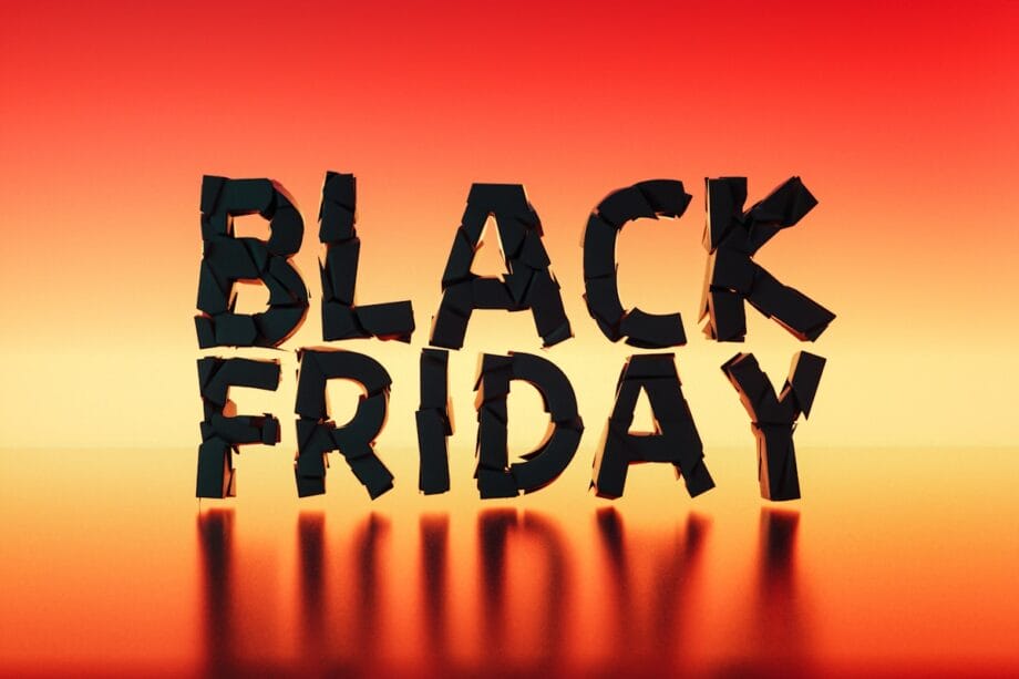 Black Friday text in bold black 3D letters on a red and orange gradient background with reflections below.