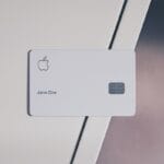 A white Apple credit card with a chip and the name Jane Doe rests on a white surface.