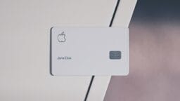 A white Apple credit card with a chip and the name Jane Doe rests on a white surface.