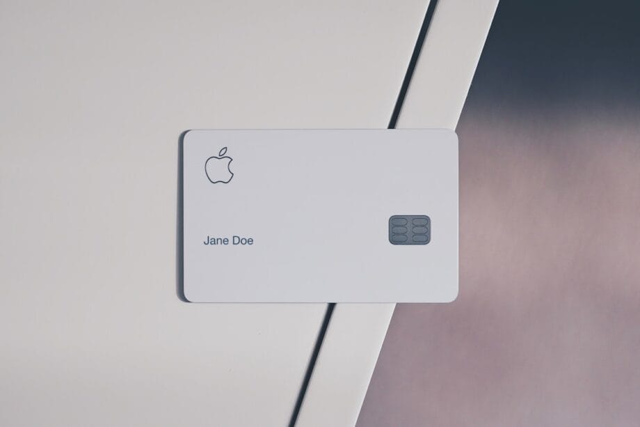 A white Apple credit card with a chip and the name Jane Doe rests on a white surface.
