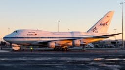 A NASA SOFIA Boeing 747 aircraft is parked on the tarmac at sunrise, with visible DLR and NASA logos.