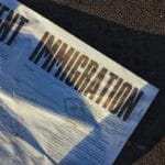 A close-up of a document on the ground with the word IMMIGRATION printed in bold letters.
