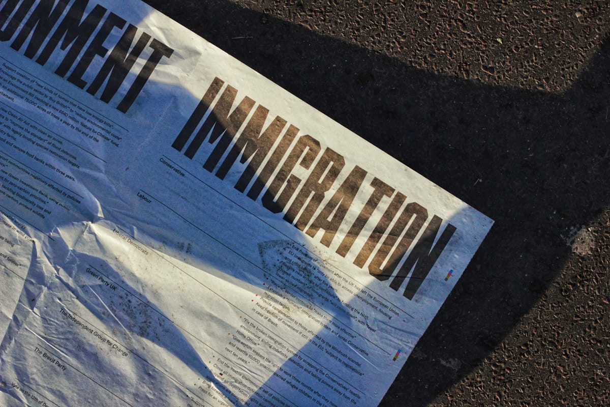 A close-up of a document on the ground with the word IMMIGRATION printed in bold letters.