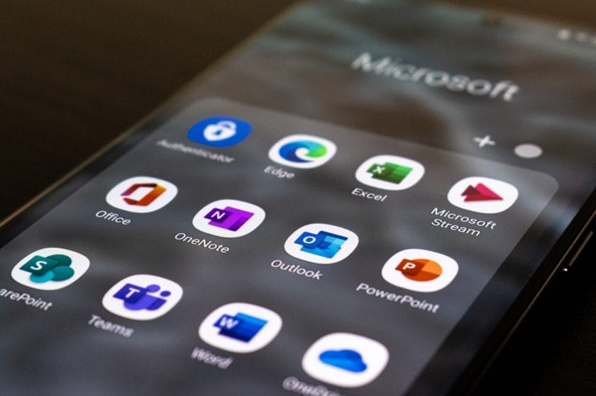 A smartphone screen displays several Microsoft app icons, including Office, Outlook, Word, Teams, Excel, and PowerPoint.