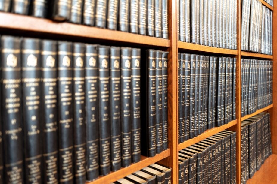 Close-up of shelves filled with rows of hardcover encyclopedias in black bindings with gold lettering.