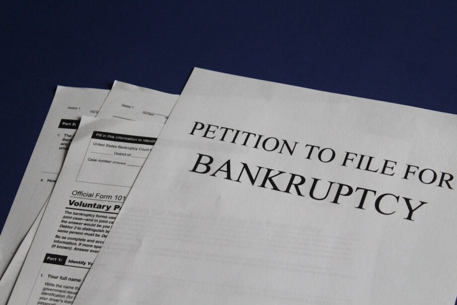 Close-up of bankruptcy petition documents on a blue surface.