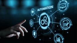 A hand points to a digital interface displaying the word Automation surrounded by various technology and data icons.