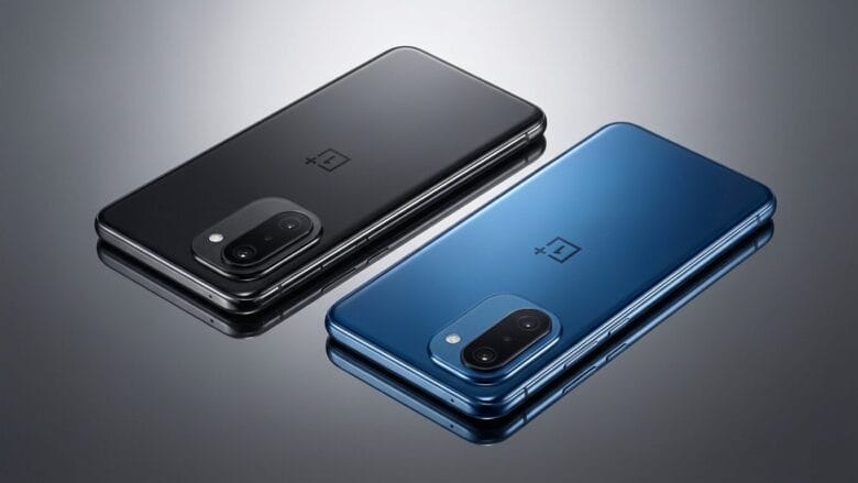Two OnePlus smartphones, one black and one blue, are placed side by side on a reflective surface, showing their rear sides and cameras.