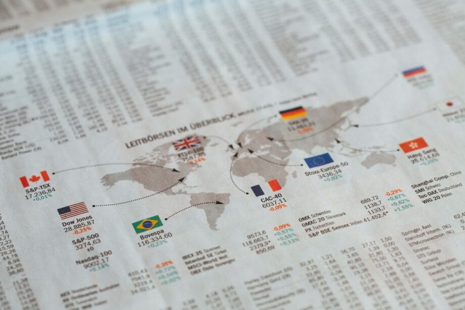 A world map shows major stock indices with country flags and index values, overlaid on financial data tables.