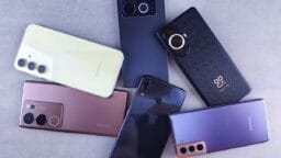 Six different smartphones from various brands are arranged on a flat, light gray surface.