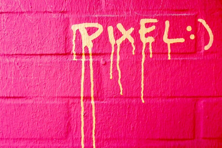 Yellow paint spelling PIXEL: drips down a pink brick wall.