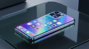 A modern smartphone with a metallic frame and triple camera sits on a glass surface, displaying a colorful home screen with app icons.