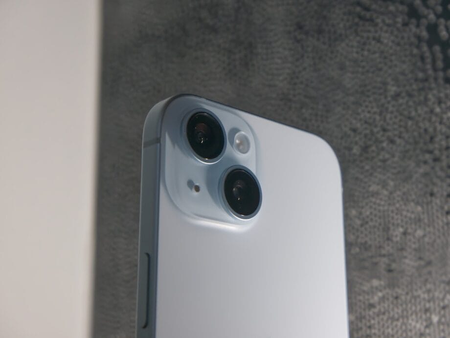 Close-up of the back of a white smartphone showing two camera lenses and a flash module.