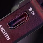 Close-up of an HDMI port labeled IN on an electronic device, with visible connector pins and a surrounding red and black casing.