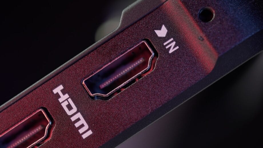 Close-up of an HDMI port labeled IN on an electronic device, with visible connector pins and a surrounding red and black casing.