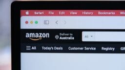 A computer screen displays the Amazon website delivering to Australia, with Safari browser tabs visible at the top.