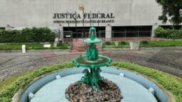 A green fountain with horse sculptures stands in front of the Justiça Federal building in Fórum Presidente Castelo Branco.