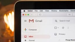 A computer screen displays the Gmail inbox interface with the Compose button and inbox folder visible.