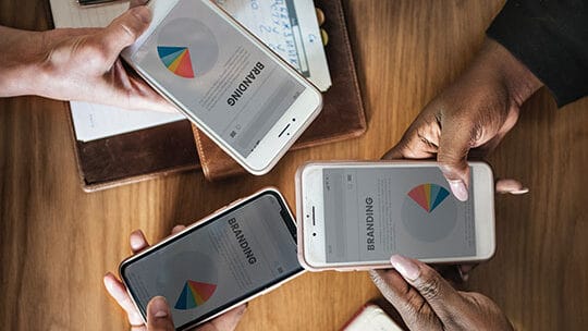 A group of hands holding cell phones.